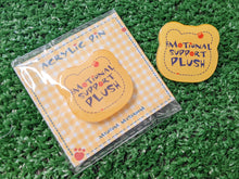 Load image into Gallery viewer, an acrylic pin shaped like a yellow bear face with the text 'EMOTIONAL SUPPORT PLUSH' and small red paw prints, shown next to its cute backing card packaging
